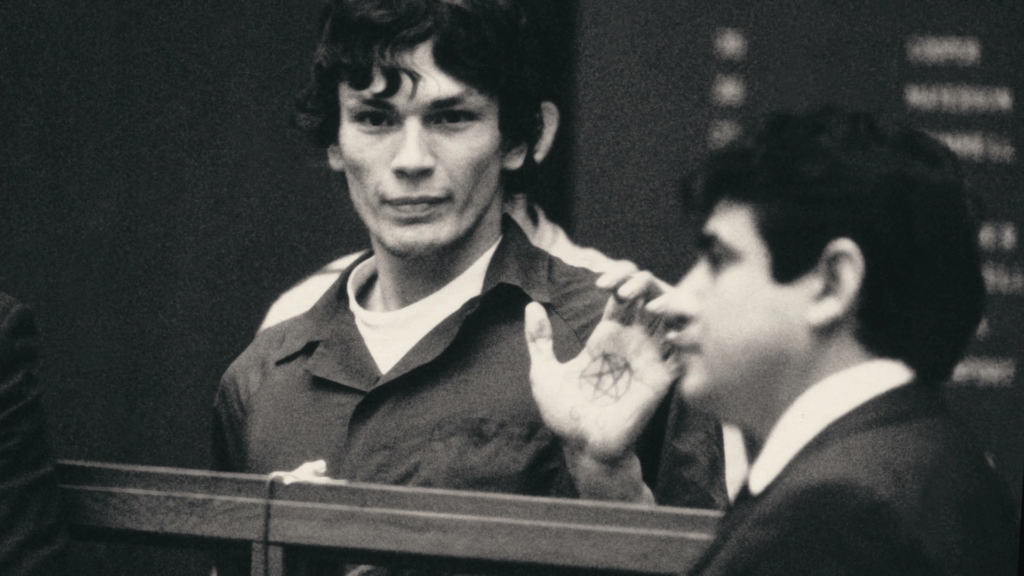 Richard Ramiraz showing his satanic symbol during his trial